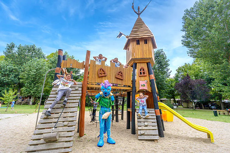 Wooden playground, children, mascot at CLICOCHIC Beau Rivage campsite, LA ROQUE-GAGEAC.