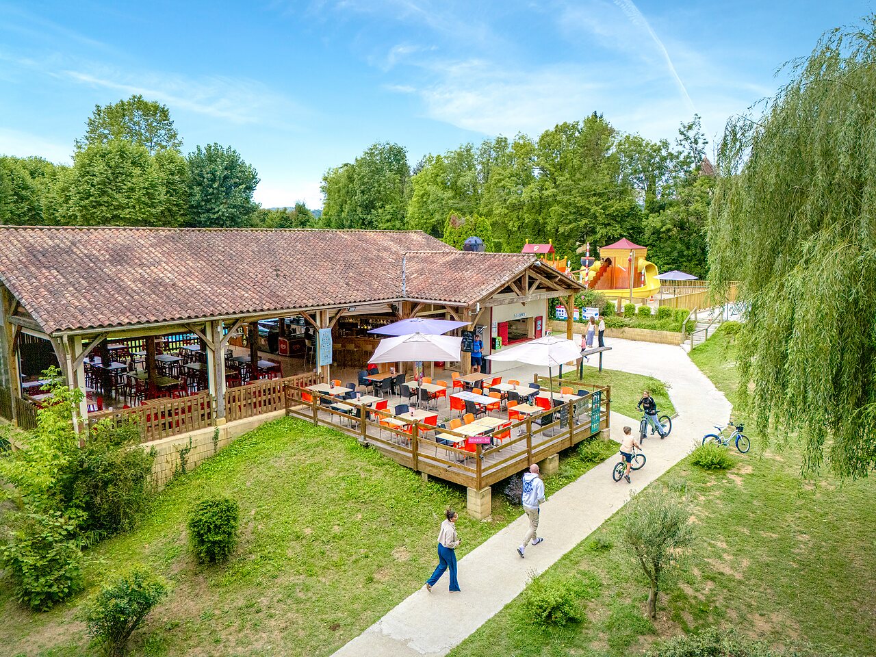 Restaurant, terrace, playground, bikes at CLICOCHIC Beau Rivage campsite in LA ROQUE-GAGEAC.