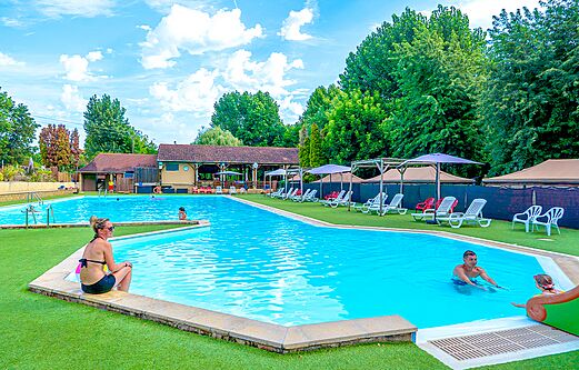 Large outdoor swimming pool with chairs and parasols at campsite CLICOCHIC Beau Rivage in LA ROQUE-GAGEAC (24).