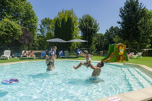 Family playing in the swimming pool with slide at campsite CLICOCHIC Beau Rivage in LA ROQUE-GAGEAC (24).