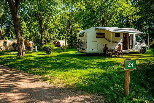Green camping pitch with motorhome. CLICOCHIC Beau Rivage, LA ROQUE-GAGEAC (24).