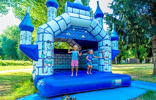 Blue and white bouncy castle with children jumping at CLICOCHIC Beau Rivage campsite in LA ROQUE-GAGEAC (24)