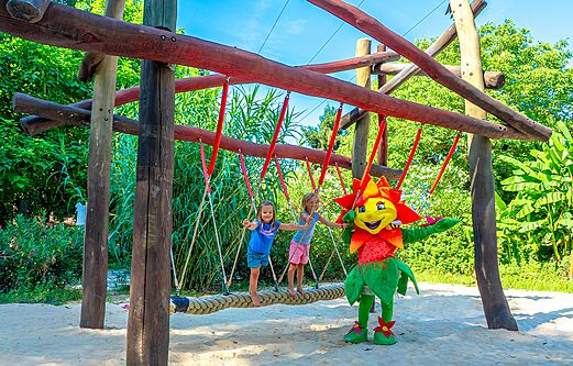 Two children and a mascot on a rope bridge in the playground at camping CLICOCHIC Beau Rivage in LA ROQUE-GAGEAC (24).