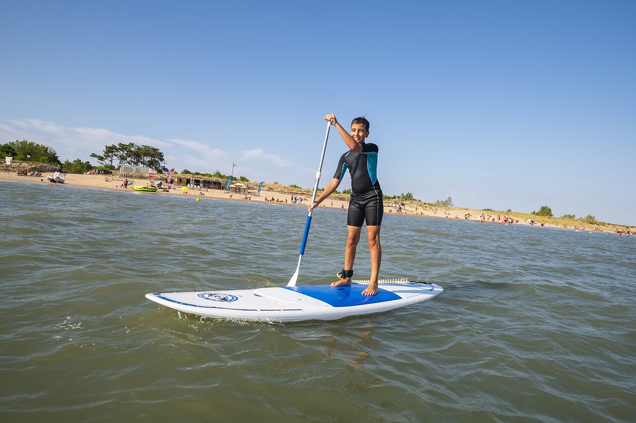 Paddleboard, young person, beach at CAPFUN Bel Air campsite in Aiguillon sur Mer (85).