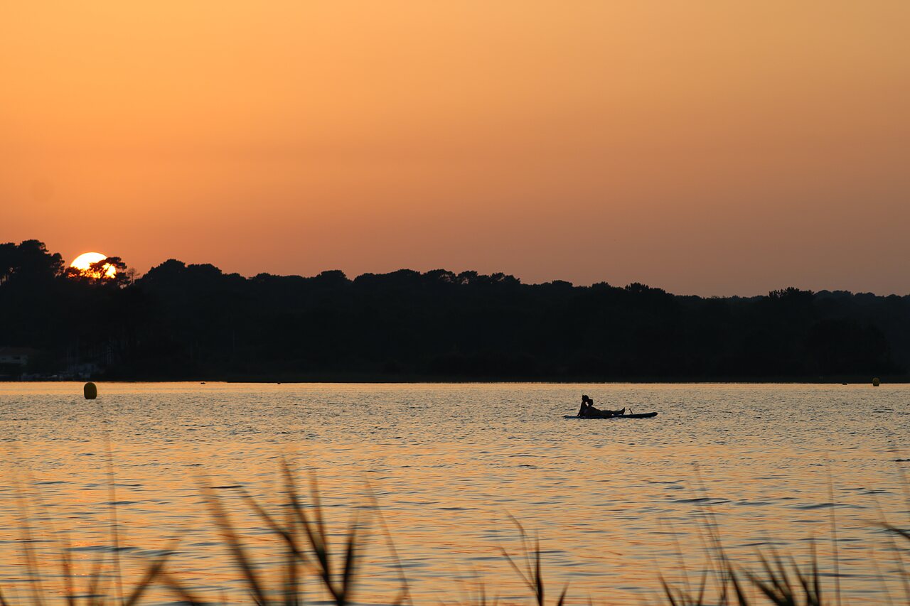 Paddleboarder on lake at sunset, campsite CLICOCHIC Bimbo in BISCARROSSE (40).