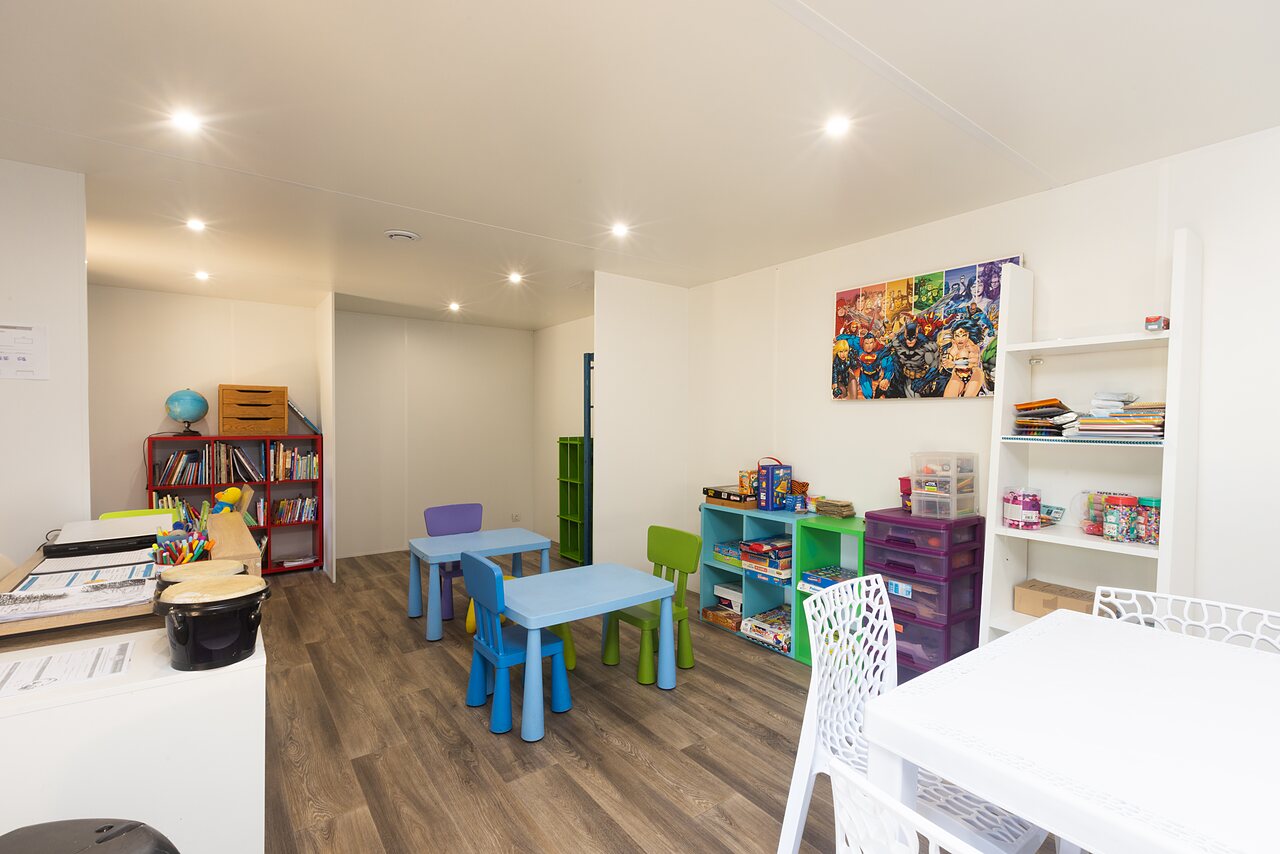 Indoor kids' play area with tables, books at camping CLICOCHIC Bimbo in BISCARROSSE.