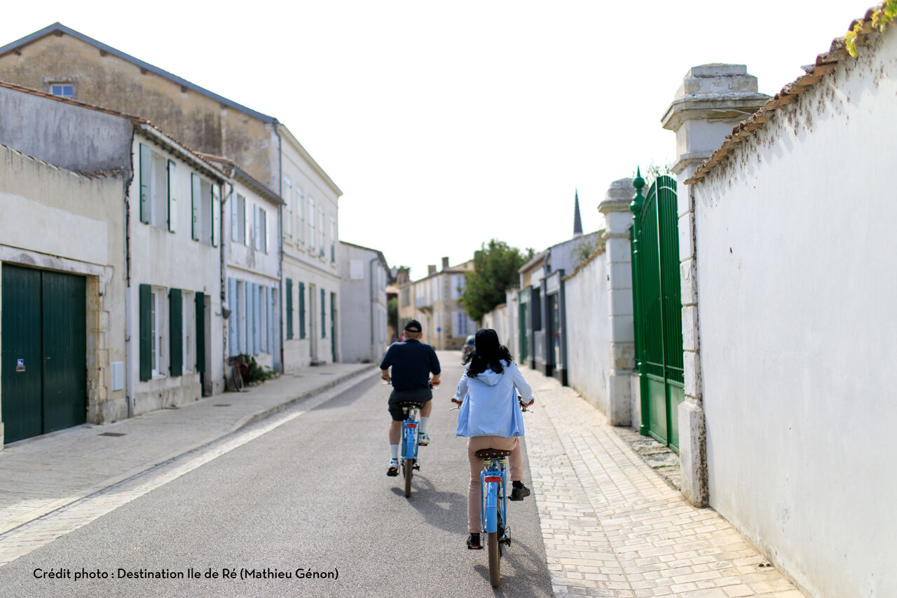 Couple cycling through a typical street on �le de R�.