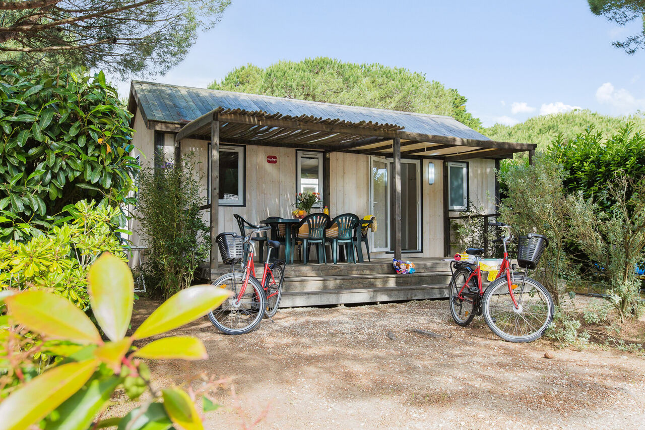 Mobile home with terrace, table, chairs and bikes at CAPFUN Bonne Etoile campsite in BOIS PLAGE EN RE (17).