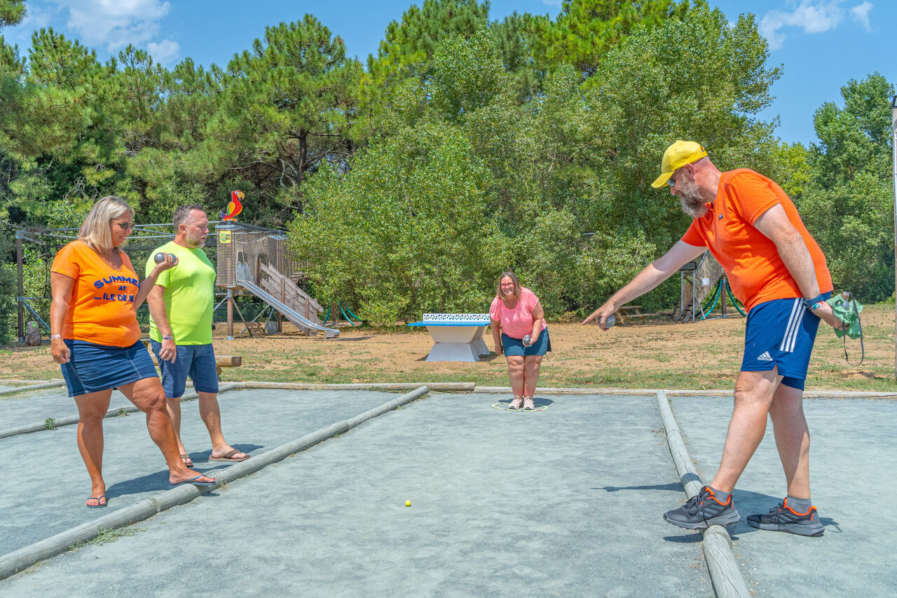 P�tanque game among adults, games in background at CAPFUN Bonne Etoile campsite in BOIS PLAGE EN RE (17).