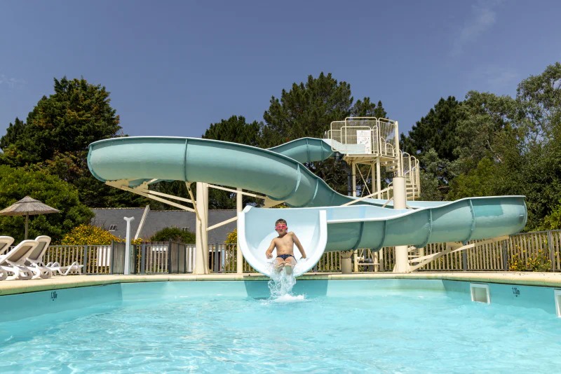 Water slide and swimming pool with child at CLICOCHIC Bord�n�o Belle-�le-en-Mer campsite in Le Palais (56).