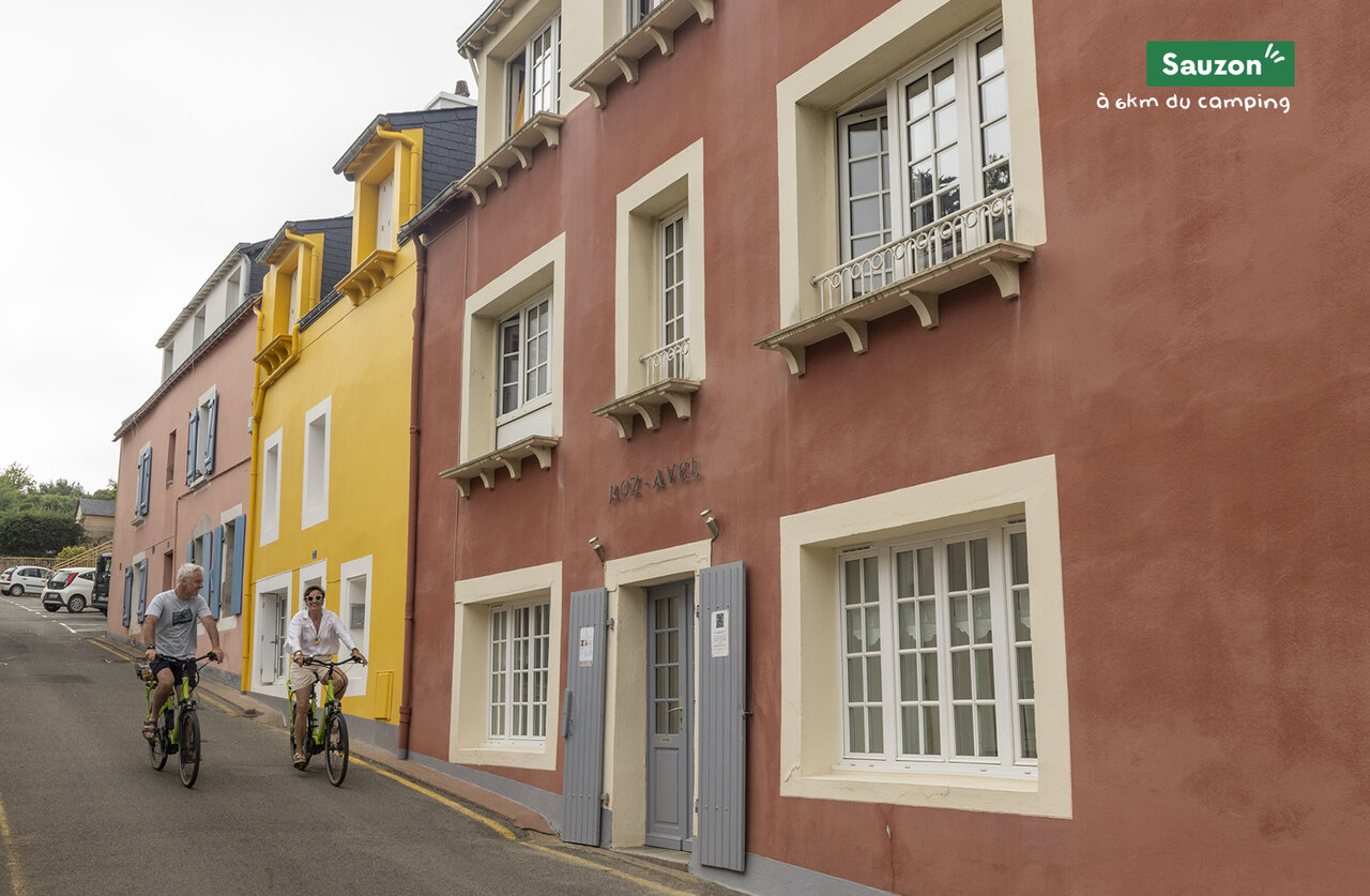 Colorful street and cyclists in Sauzon, town to visit near campsite.