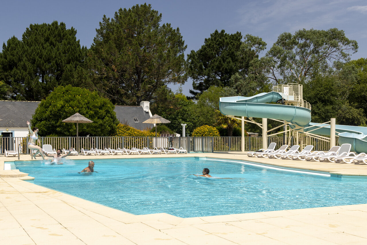 Outdoor swimming pool with water slide and swimmers at camping CLICOCHIC Bord�n�o Belle-�le-en-Mer in Le Palais (56).