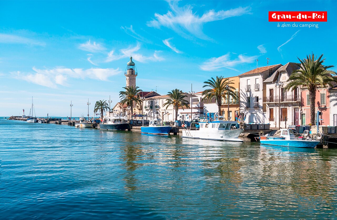 Lively fishing port of Grau-du-Roi with boats and lighthouse.