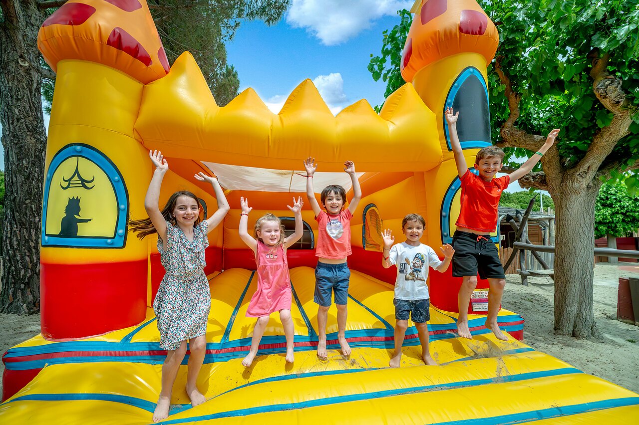 Inflatable castle and happy children at CAPFUN Boucanet campsite in LE GRAU DU ROI (30).