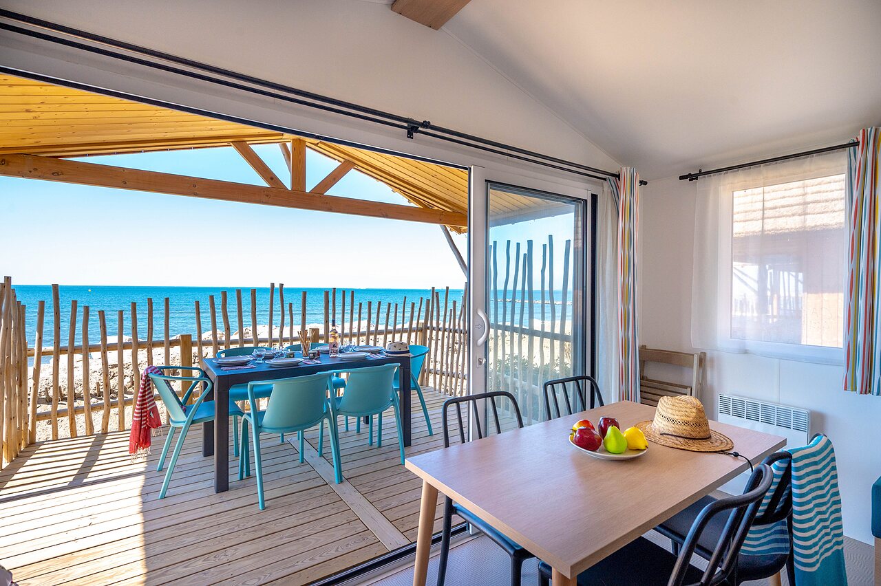 Accommodation terrace with table, chairs and sea view on the beach at CAPFUN Boucanet campsite in LE GRAU DU ROI (30).