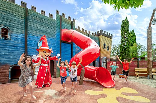 Castle playground with red slide and happy children at CAPFUN Boucanet campsite in LE GRAU DU ROI (30)