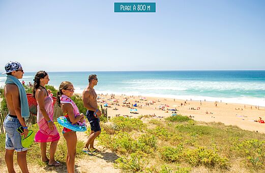 Family looking at the sandy beach and ocean at VAGUES OCEANES Boudigau campsite in LABENNE OCEAN (40).