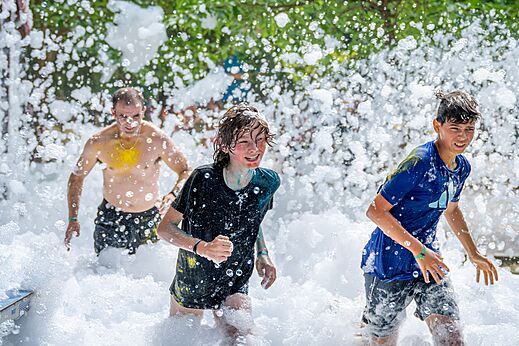 Foam party with smiling children and adults at VAGUES OCEANES Boudigau campsite in LABENNE OCEAN (40).