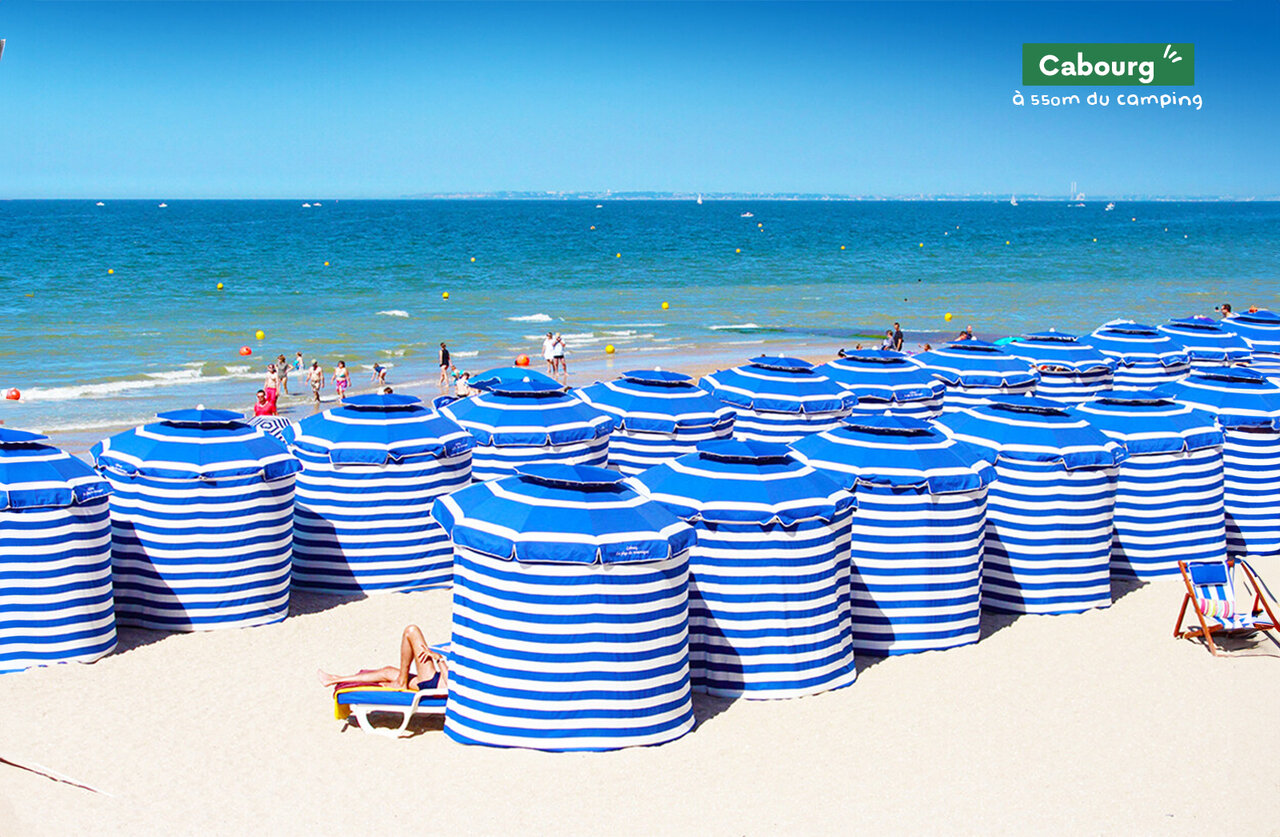 Cabourg beach with striped tents, a beautiful place to visit in Normandy.