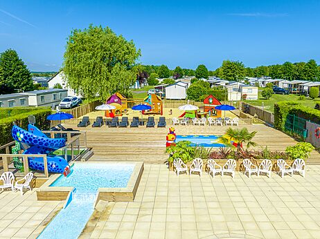 Paddling pool, slide and children's playground at CLICOCHIC Brise de Cabourg campsite.