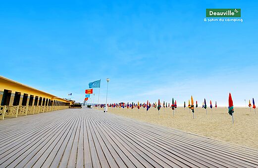 Deauville boardwalk, beach with colorful umbrellas and beach cabins, Normandy.