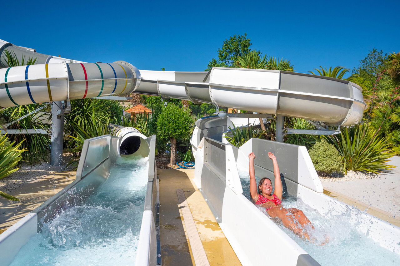 Smiling woman on water slide at camping CLICOCHIC Cabanes d Ol�ron in ST GEORGES D'OLERON.