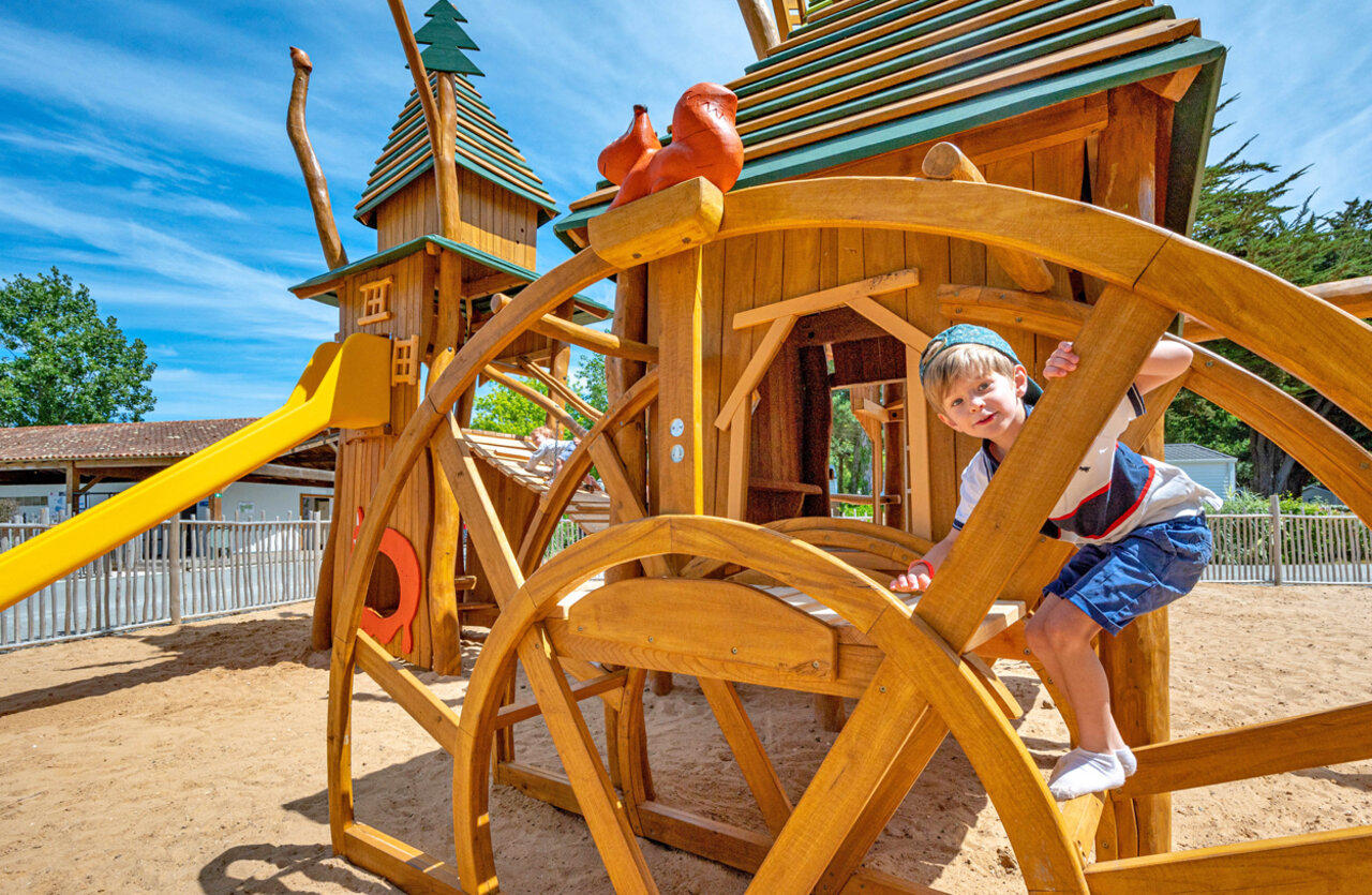 Child, wooden playground at CLICOCHIC Cabanes d Ol�ron campsite in ST GEORGES D'OLERON (17).