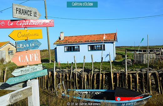 Colorful signpost and typical waterside house in Château d'Oléron.