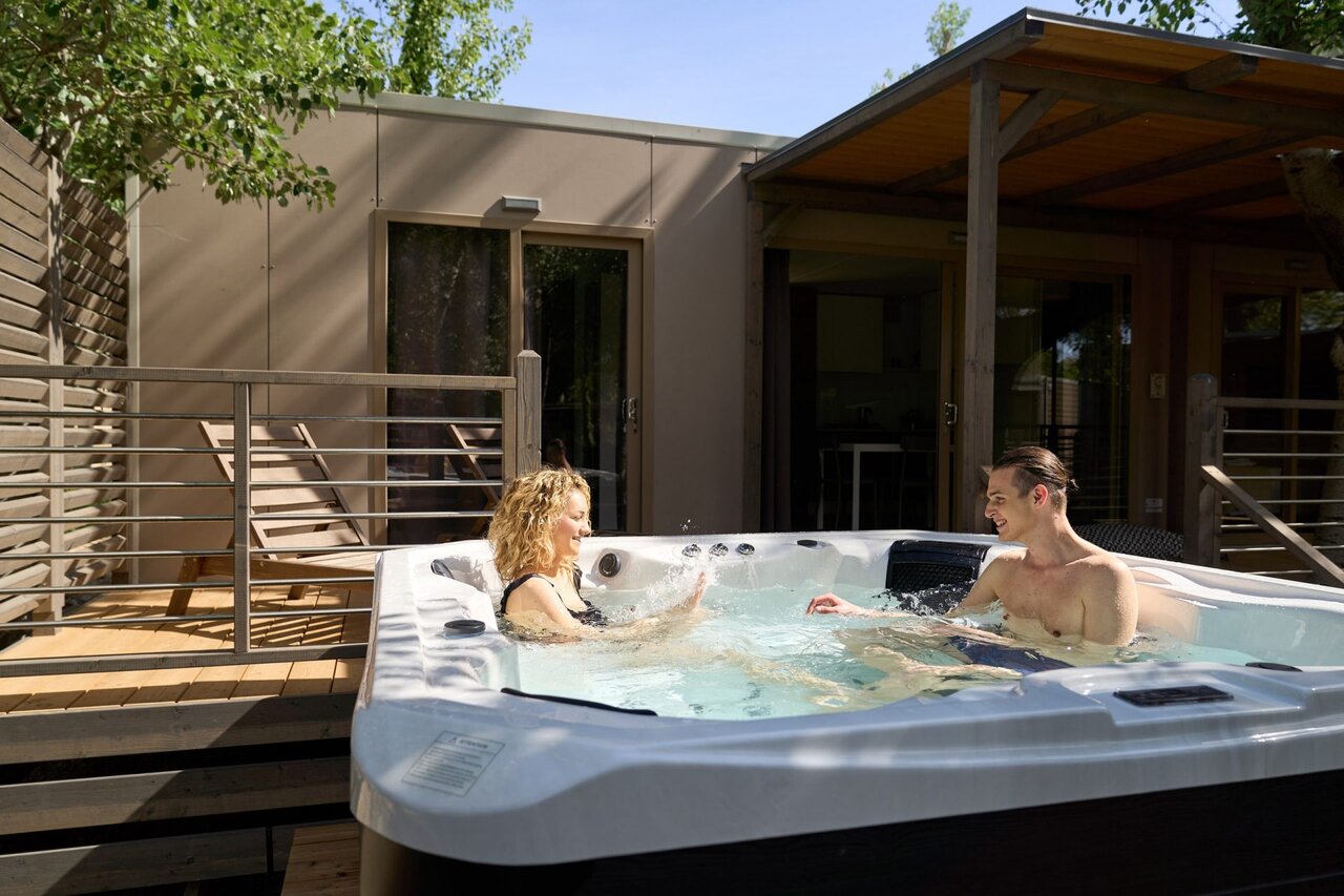 Private jacuzzi with couple on mobile home terrace at CAPFUN Campo dei Fiori campsite in Rosignano Marittimo (57).