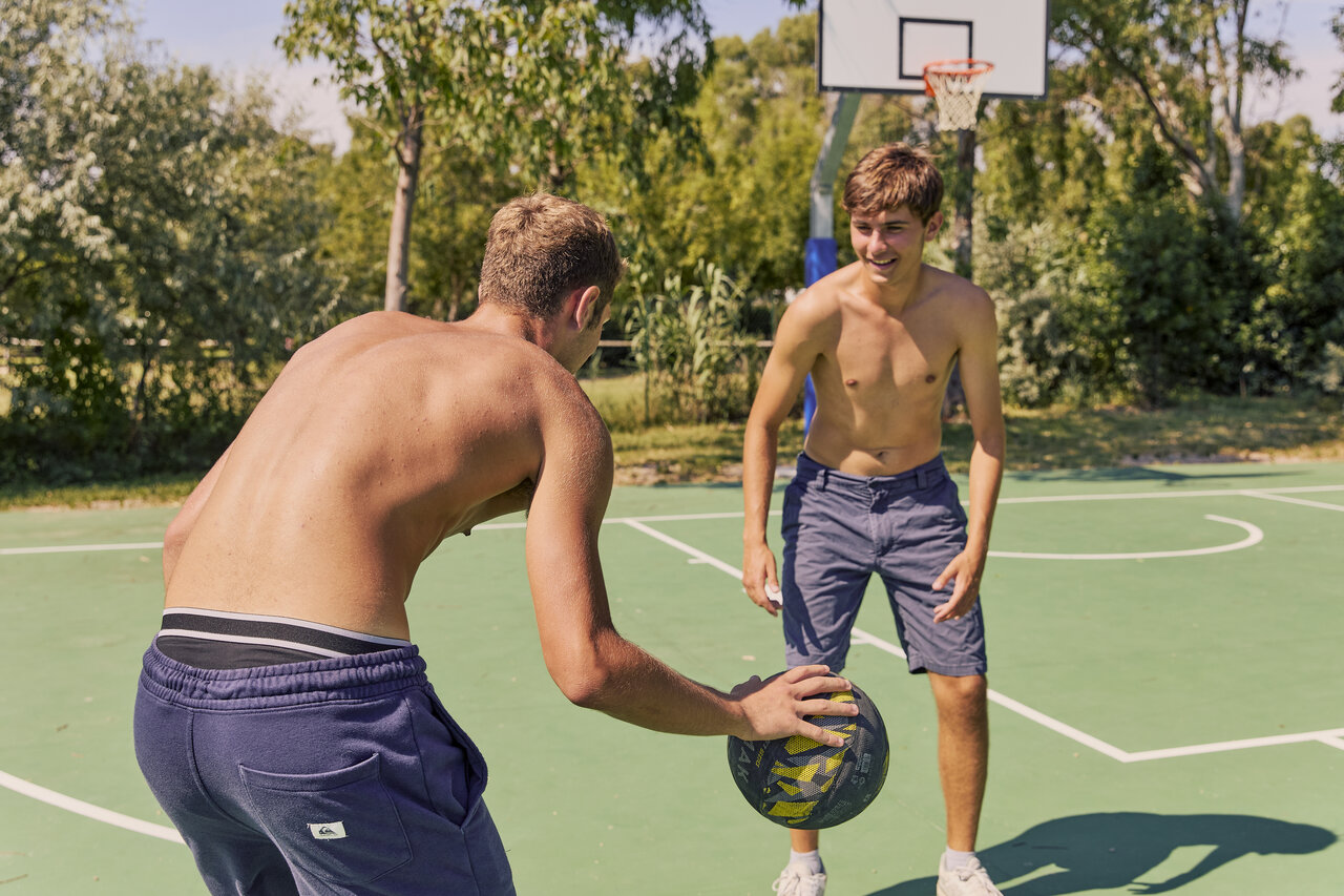 Young people playing basketball on multisport court at CAPFUN Campo dei Fiori campsite in Rosignano Marittimo (57).