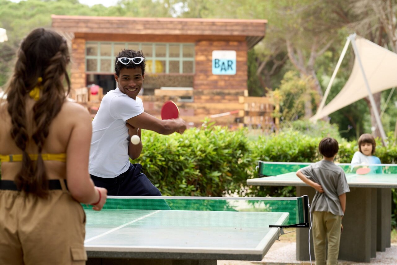 Family table tennis near the bar at CAPFUN Campo dei Fiori campsite in Rosignano Marittimo.