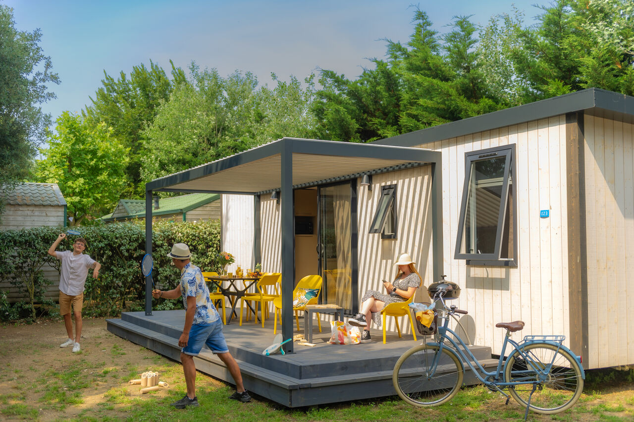 Modern mobile home, family playing, at CLICOCHIC Camp du Soleil campsite in Ars-en-R�.