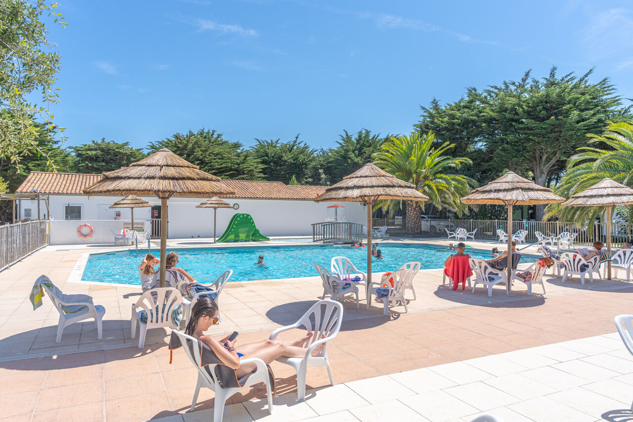 Outdoor swimming pool with slide and sun loungers, at CLICOCHIC Camp du Soleil campsite in Ars-en-R� (17).