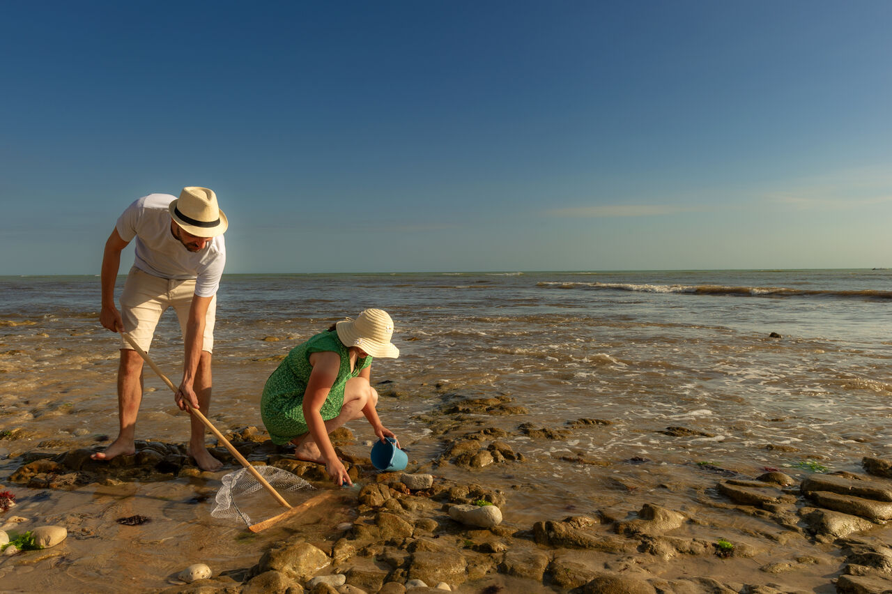 Couple shore fishing on a rocky beach at CLICOCHIC Camp du Soleil campsite in Ars-en-R� (17).