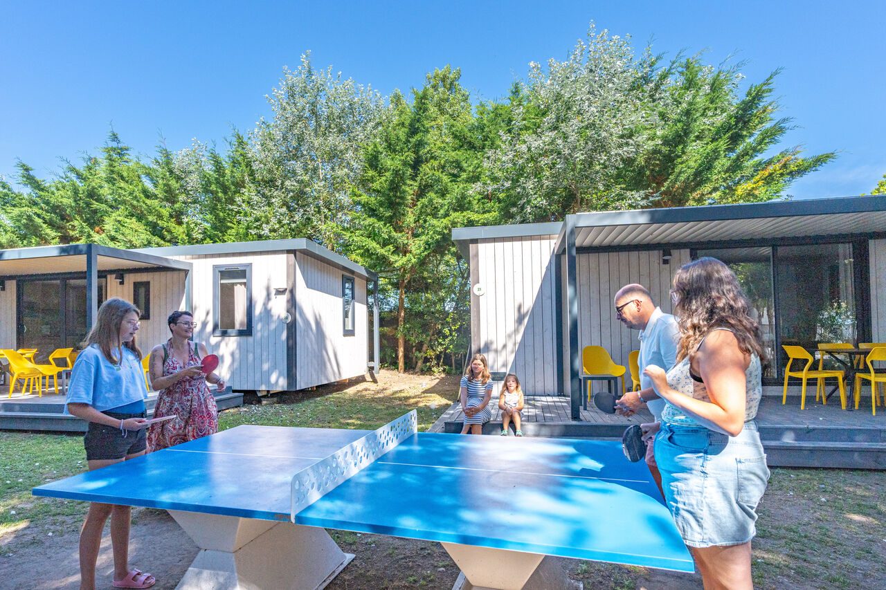 Family playing table tennis at CLICOCHIC Camp du Soleil campsite.