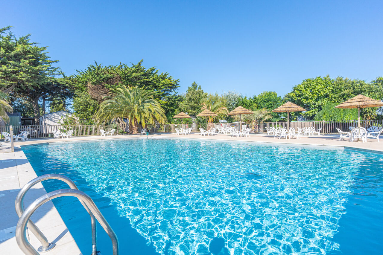 Outdoor swimming pool, sun loungers and parasols at CLICOCHIC Camp du Soleil campsite.