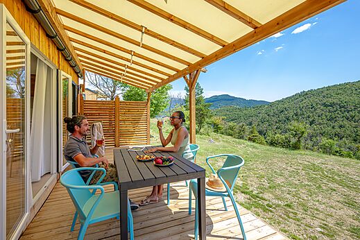 Couple on Mobil-home terrace with mountain view at CLICOCHIC Castillon de Provence.