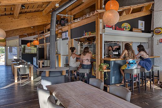 Wooden bar and restaurant with guests at CLICOCHIC Castillon de Provence campsite in Castellane (04).