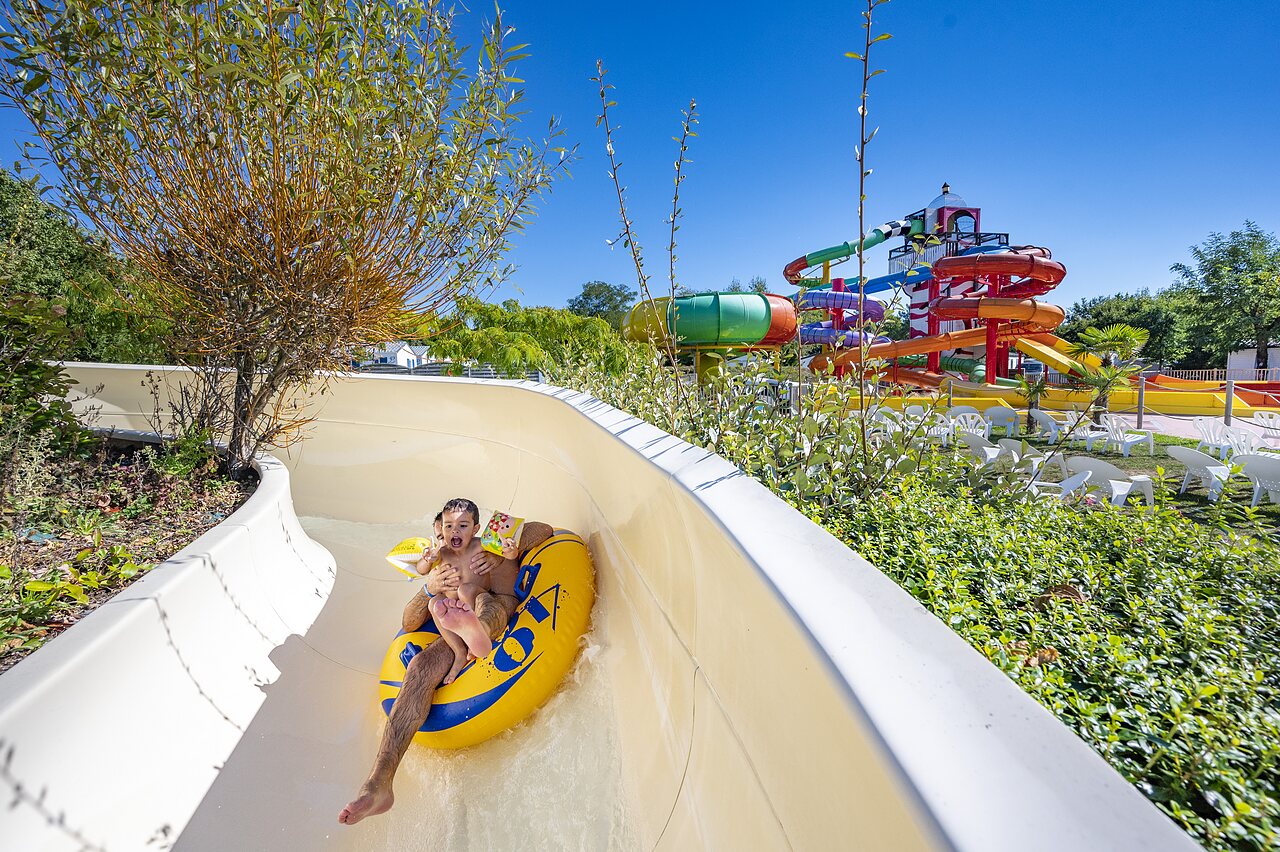 Child and adult on tube in water slide at CAPFUN Cenic campsite in PENESTIN (56).