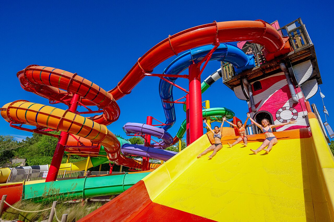 Colorful water slides with happy children at CAPFUN Cenic campsite in PENESTIN (56).
