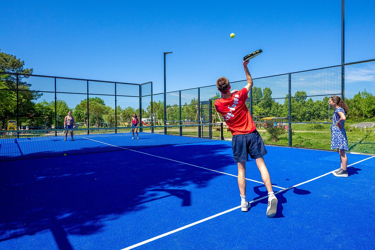 Blue padel court with players at CAPFUN Cenic campsite in PENESTIN (56).