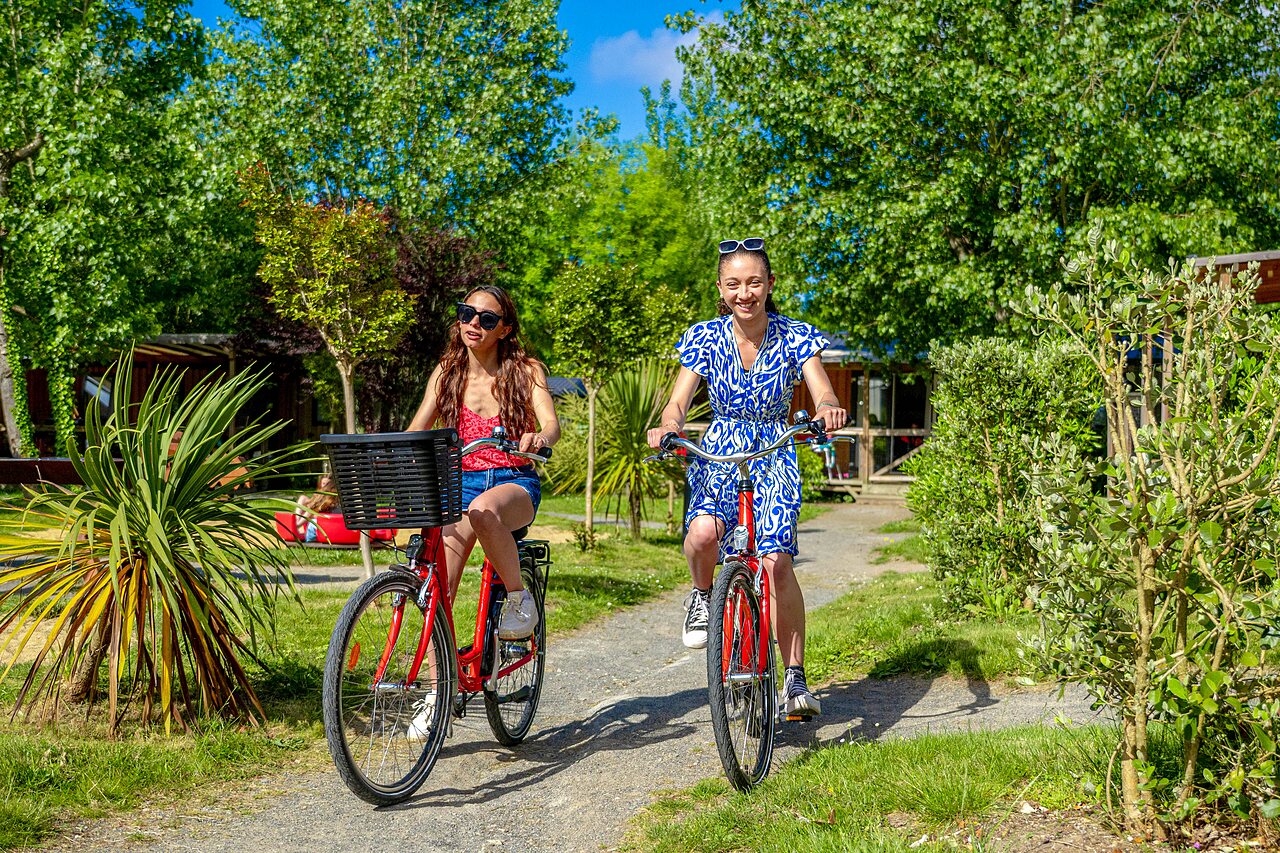 Women cycling on green path at CAPFUN Cenic campsite in PENESTIN (56).