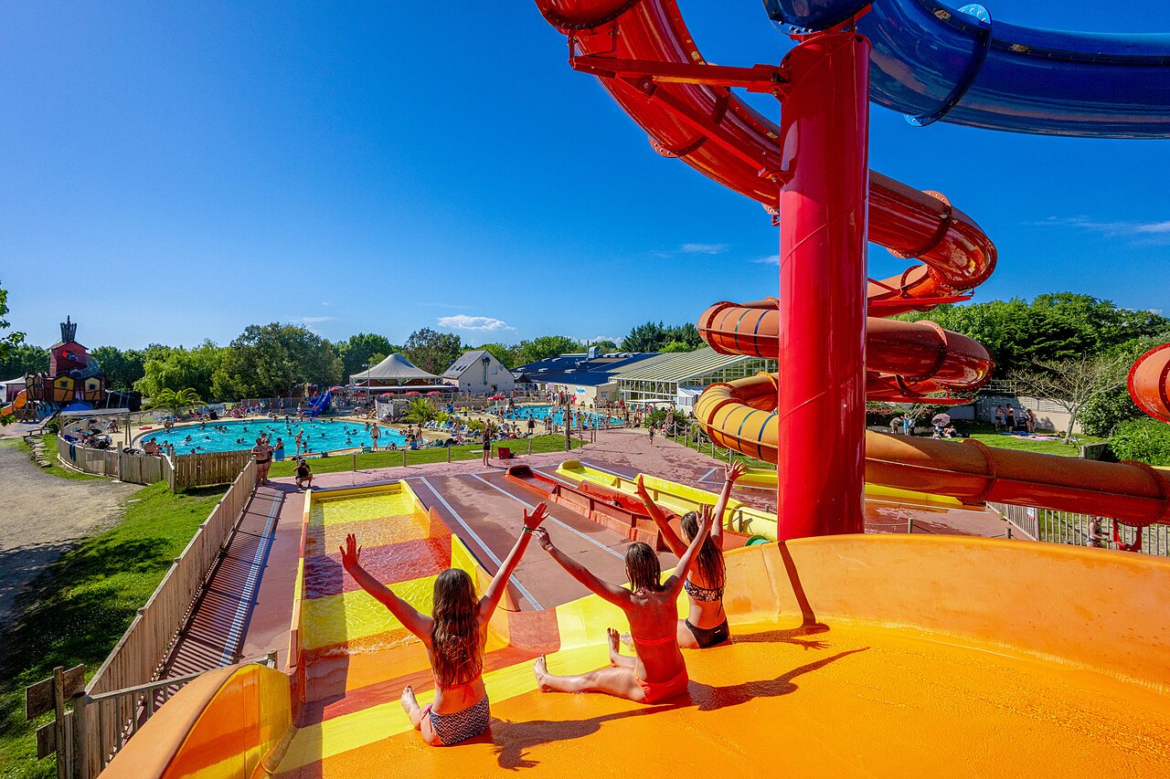 Colorful water slides and lively outdoor swimming pool at CAPFUN Cenic campsite in PENESTIN (56).