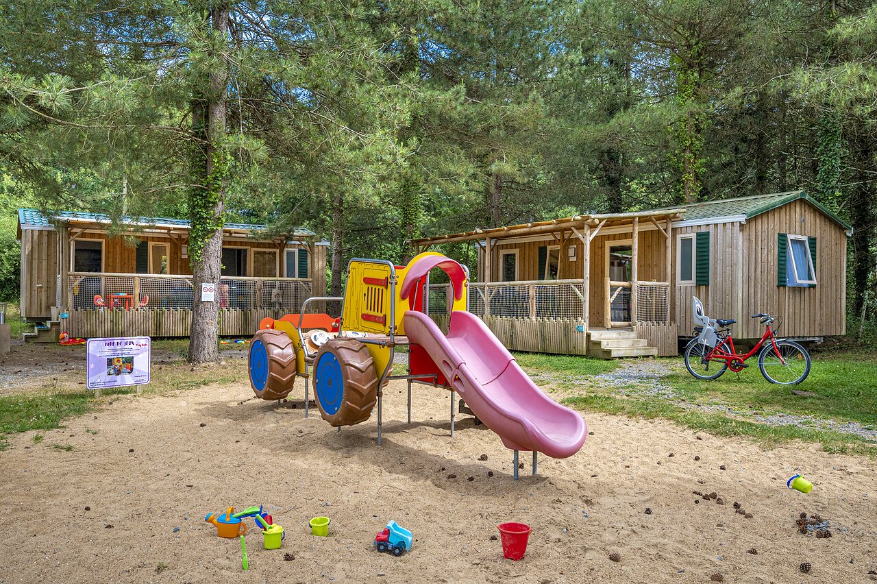 Playground with slide and Mobile homes at CAPFUN Cenic campsite in PENESTIN (56).