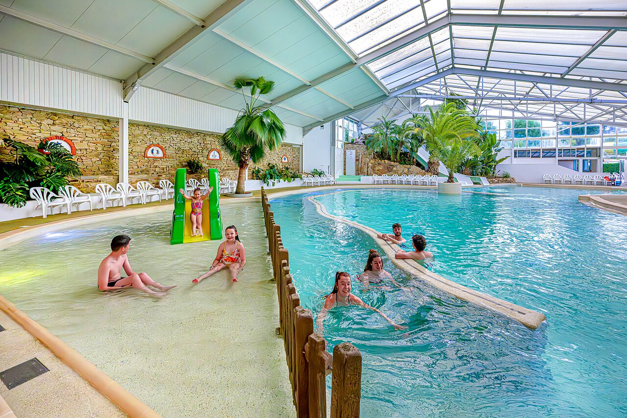 Indoor swimming pool with slide, river and children at CAPFUN Cenic campsite in PENESTIN (56).