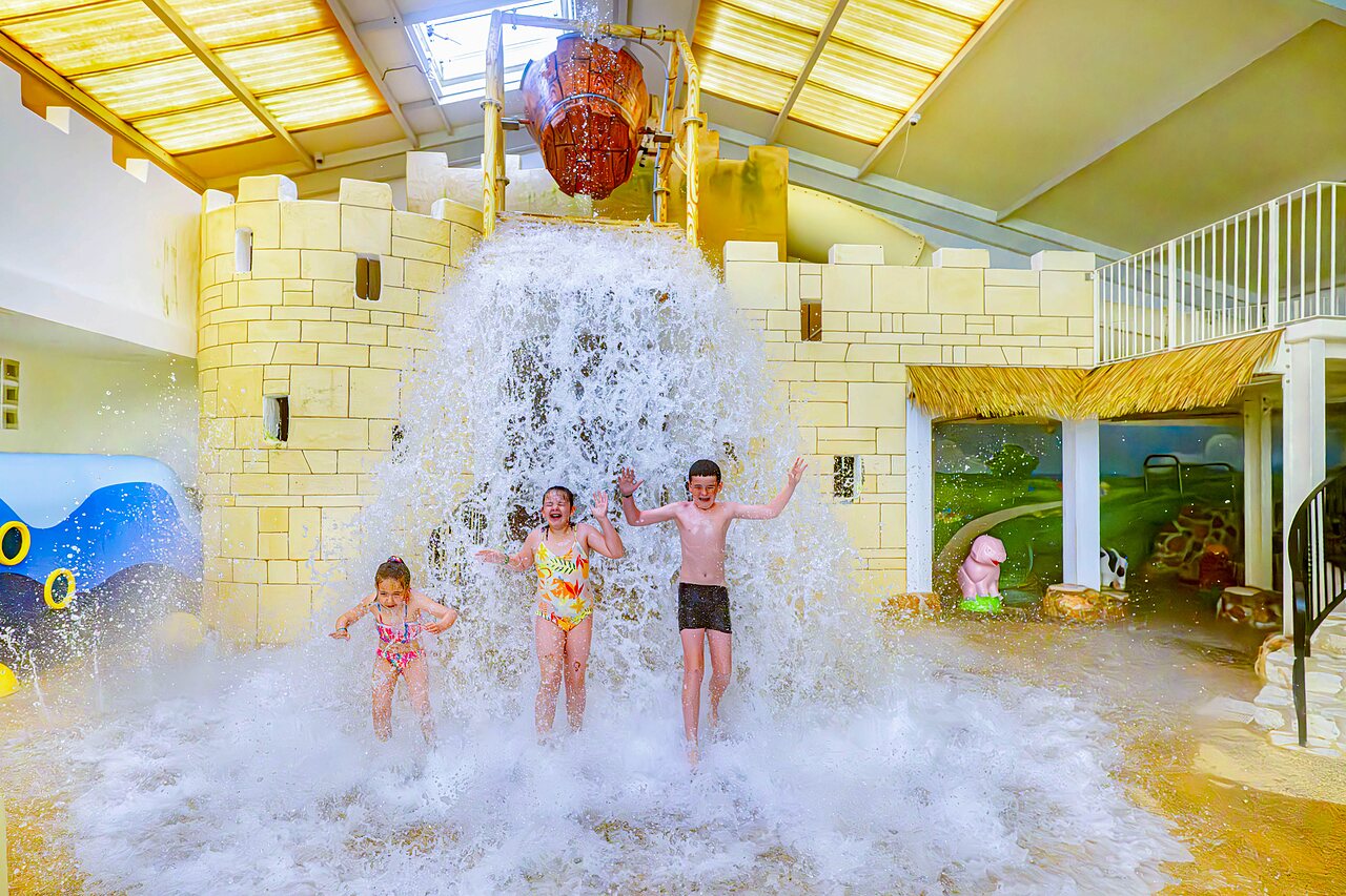 Children under the giant water bucket in the pool at CAPFUN Cenic campsite in PENESTIN (56).