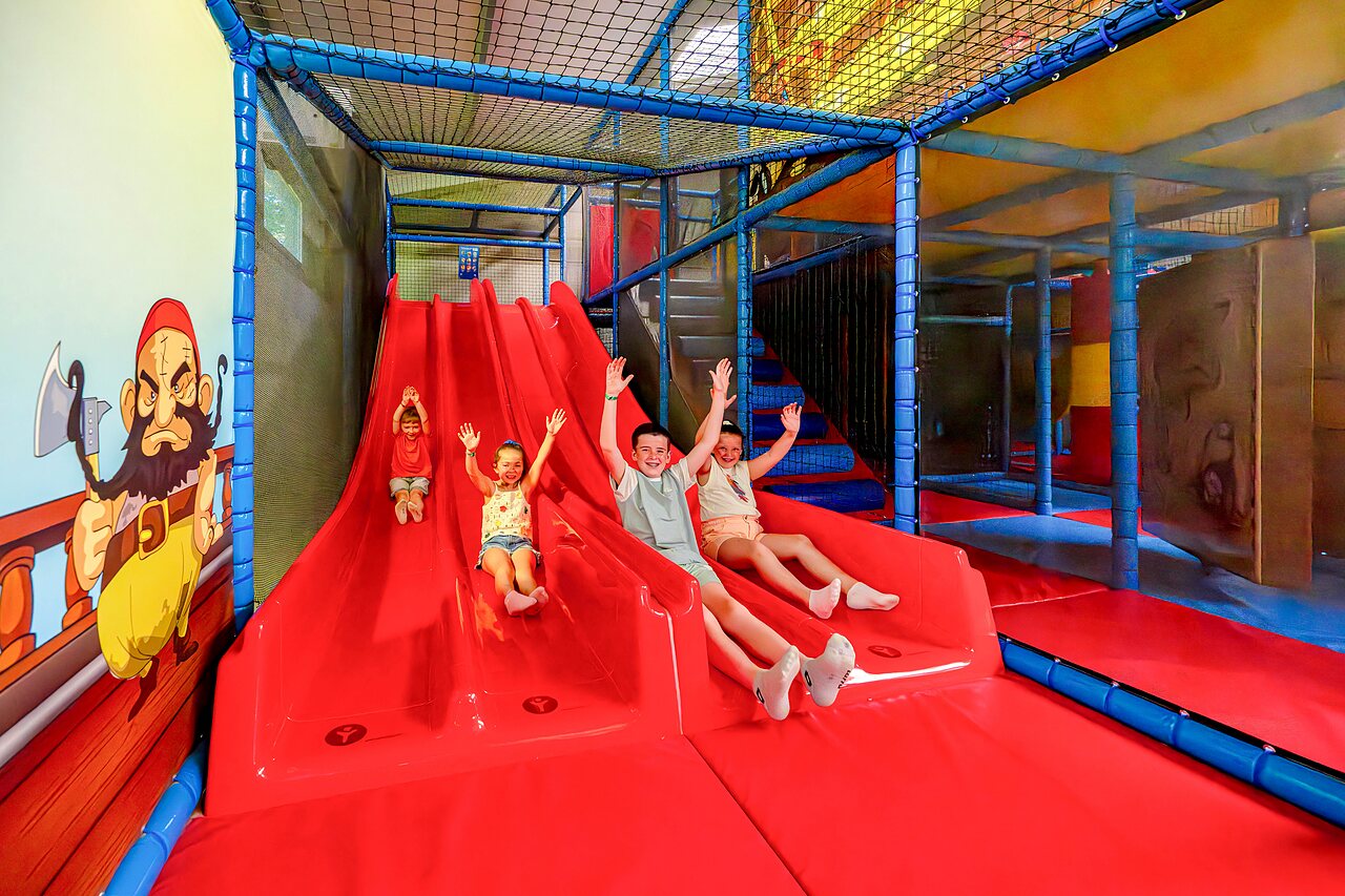 Indoor play area with slides and children at CAPFUN Cenic campsite PENESTIN (56).