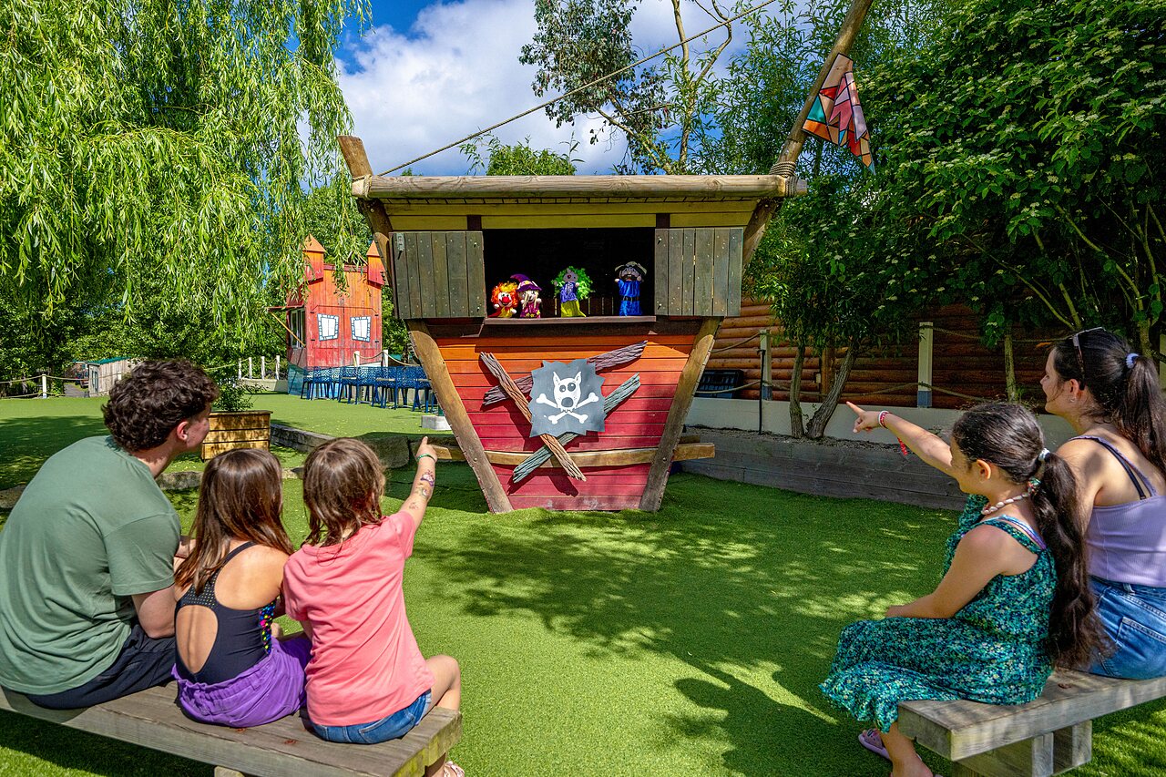 Puppet show for children, family seated at CAPFUN Cenic campsite in PENESTIN (56).