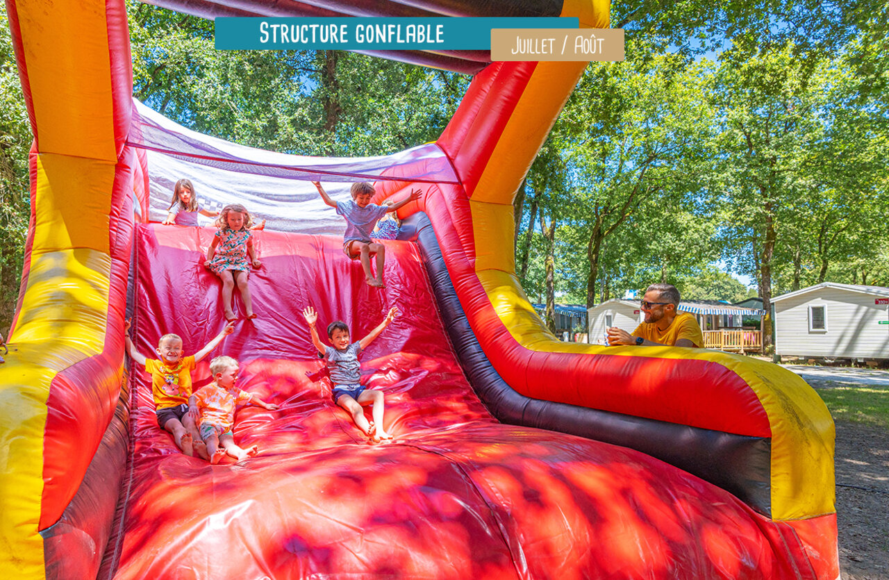 Giant inflatable structure with happy children at VAGUES OCEANES Domaine les Charmilles campsite.