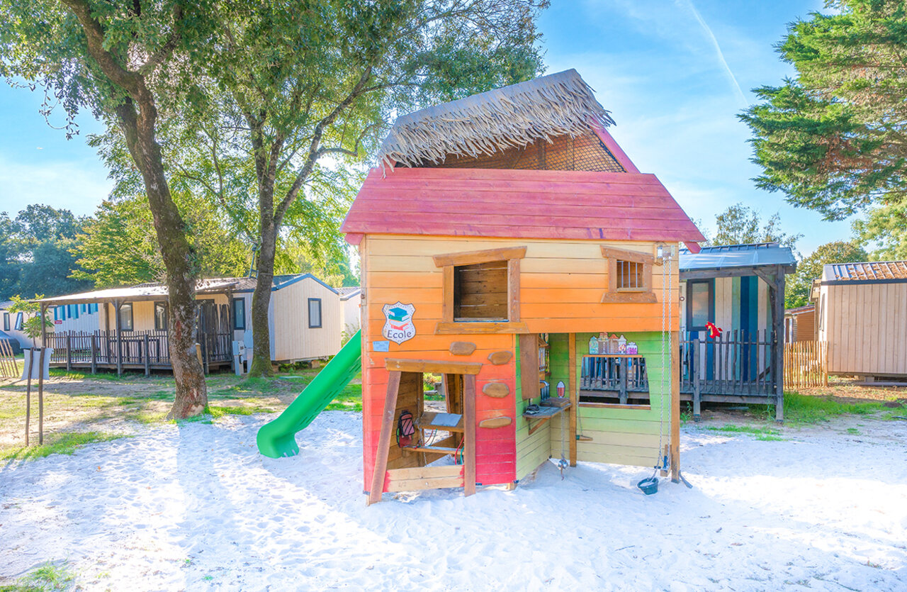 Playhouse, slide, mobile homes at VAGUES OCEANES Domaine les Charmilles campsite.